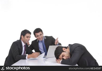 Colleagues making fun of fellow businessman sleeping
