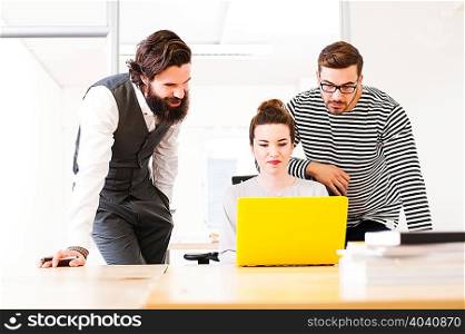 Colleagues using laptop at desk