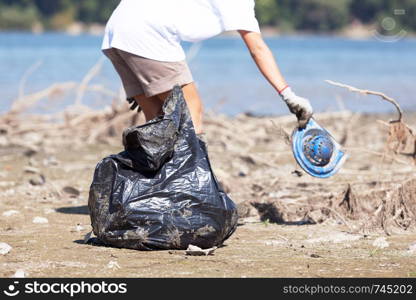 Collecting plastic waste at river or lake bank