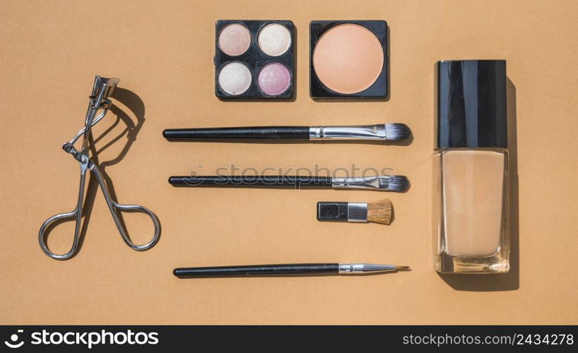 collection make up cosmetic beauty products arranged ochre background