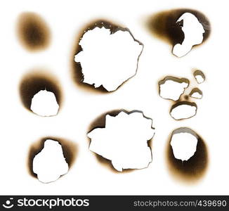 Collection of burnt holes in a piece of paper isolated on white background