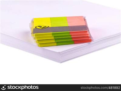 collection of colorful post it paper note on a stack of white paper. Empty colorful post its on on a stack of white paper