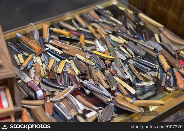 Collection of Coloured and Worn Knives with Folding Blade Scattered on the table.. Collection of Coloured and Worn Knives with Folding Blade Scattered on the table