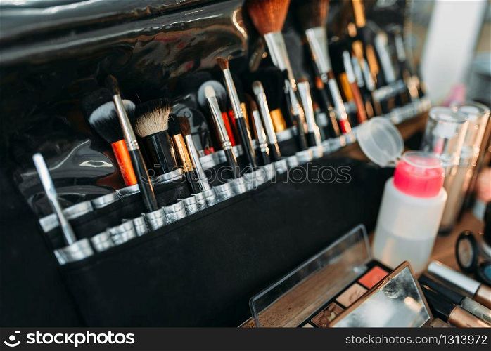 Collection of cosmetology tools on wooden table. Professional makeup artist cosmetic accessories, closeup. Collection of cosmetology tools on wooden table