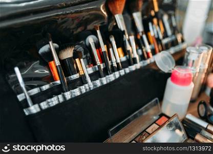 Collection of cosmetology tools on wooden table. Professional makeup artist cosmetic accessories, closeup. Collection of cosmetology tools on wooden table