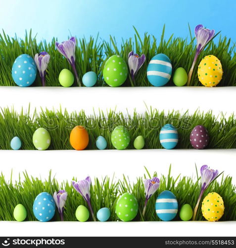Collection of decorated easter eggs and flowers in grass with copy space