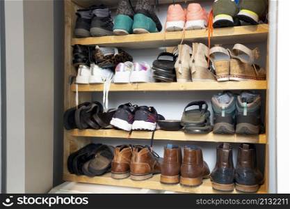 Collection of different shoes in shoe rack for storage, messy and needs organize, wardrobe with shelfs in house interior design stylish decoration close up. Collection of different shoes in shoe rack for storage, messy and needs organize, wardrobe with shelfs in house interior design stylish decoration