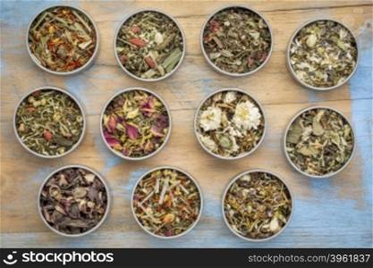 collection of eleven herbal blend Chinese tea in round metal cans, top view against painted grunge wood with a copy space