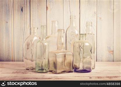 Collection of empty vintage glass bottle on a wooden background.. Retro bottles on a blue
