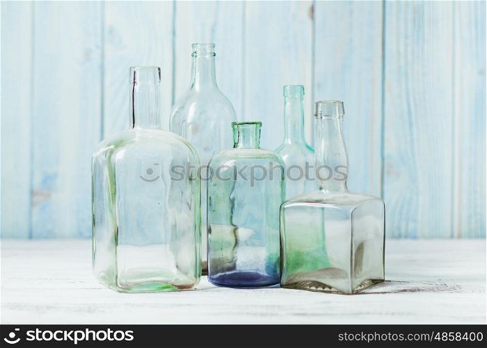 Collection of empty vintage glass bottle on a wooden background.. Retro bottles on a blue