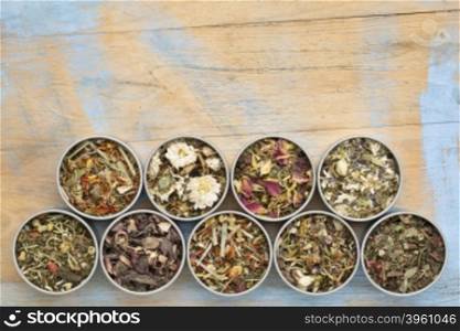 collection of nine herbal blend Chinese tea in round metal cans, top view against painted grunge wood with a copy space