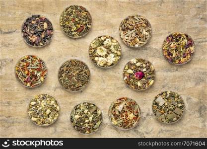 collection of twelve herbal blend Chinese tea in round bowls (Petri dish), top view on a textured handmade bark paper