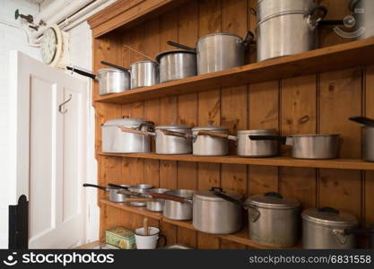 Collection of vintage saucepans on wooden kitch dresser