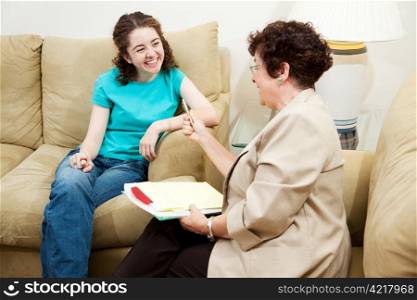 College admissions counselor or therapist interviews teen student. It&rsquo;s going well.