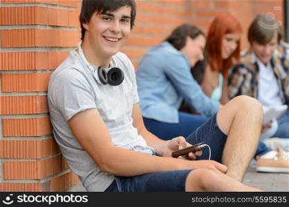College student boy sitting on ground with friends hanging out