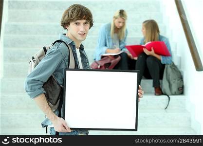 College student holding a black framed board left blank for your image