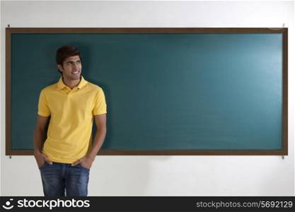 College student standing in front of blackboard