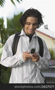 College student using a mobile phone and smiling