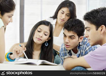 College students looking at a book