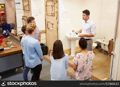 College Students Studying Plumbing Working On Washbasin