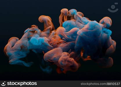 Collision of flow of red and blue ink on a dark background. Abstract concept photo.
