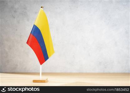 Colombia table flag on white textured wall. Copy space for text, designs or drawings