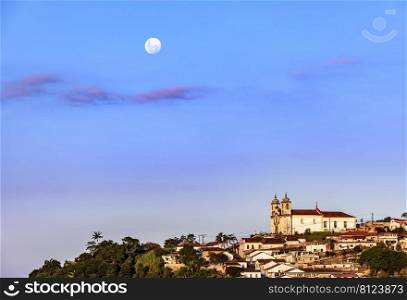 Colonial style church on the mountain with moonlight in the background in the historic city of Ouro Preto in Minas Gerais, Brazil. Colonial style church on the mountain with moonlight in the background