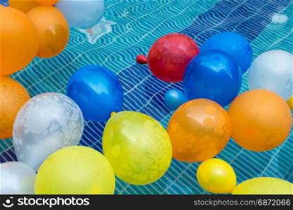 color balloons floating in a pool