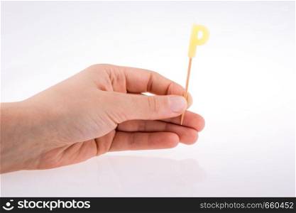 Color candle in hand on sticks writes the letter P