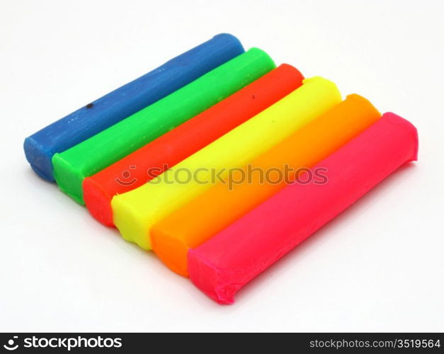 Color children&acute;s plasticine lies on a white background