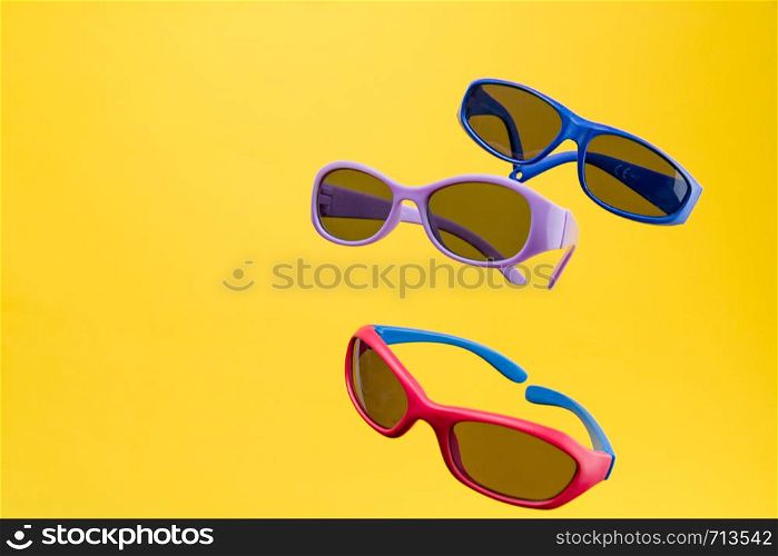 Color Children sunglasses isolated on yellow background. Concept of sun protection summer and vacation. Front view with copy space. Studio Shot