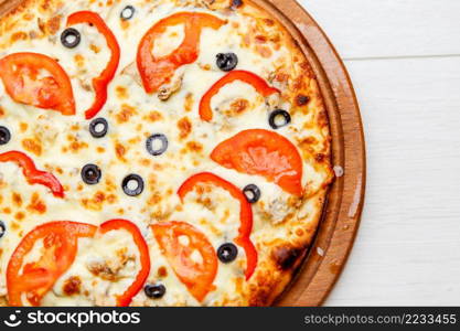 color image of fresh tasty pizza on wooden plate. pizza on wooden plate