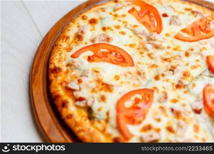 color image of fresh tasty pizza on wooden plate. pizza on wooden plate