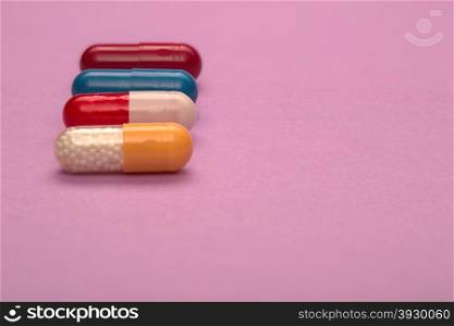 Color medical capsules text space on pink background. Color medical capsules with text space