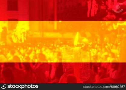 Color of Spain flag with people holding candle.. Color of Spain flag with people holding candle in background.