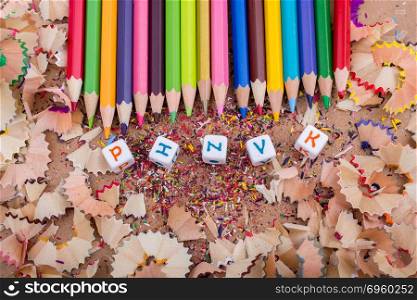 Color Pencils and letter cubes on pencil shavings. Color Pencils and letter cubes on the pencil shavings