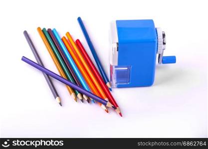 Color pencils and mechanical sharpener on white background