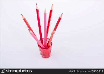 Color Pencils in a colorful glass on a white background