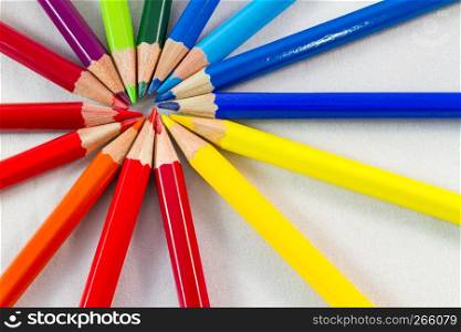 Color pencils in round formation on white background. Shot at close-up Shot at close-up with composition center at upper left