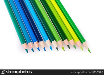 Color Pencils of various tones of green and blue color on a white background