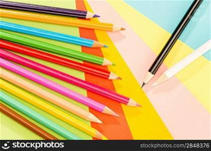 Color pencils on colorful papers close-up creativity concept