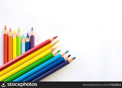 Color pencils on white paper background, copy space. Office supplies, back to school. Top view. Banner. Rows of Color pencils on white paper background, copy space. Office supplies, back to school.