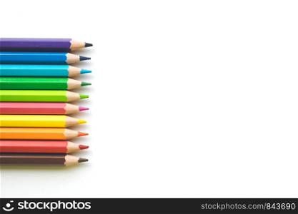 Color pencils on white paper background, copy space. Office supplies, back to school. Top view. Banner. Rows of Color pencils on white paper background, copy space. Office supplies, back to school.