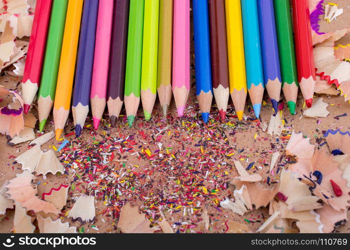 Color Pencils over a notebook with pencil shavings