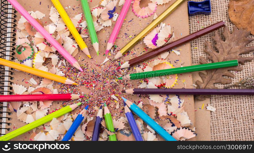 Color Pencils over a notebook with pencil shavings