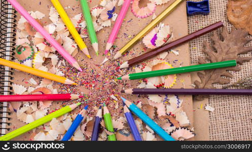 Color Pencils over a notebook with pencil shavings