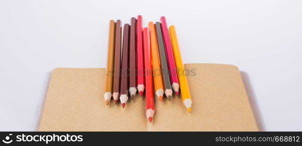 Color pencils placed on a brown notebook