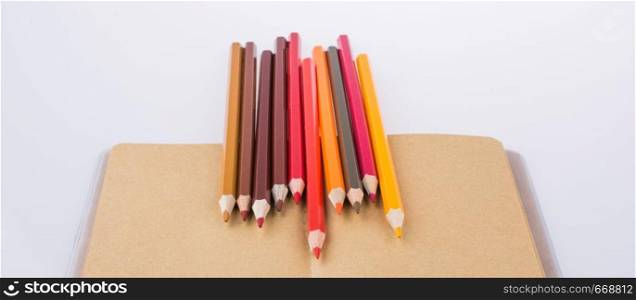 Color pencils placed on a brown notebook