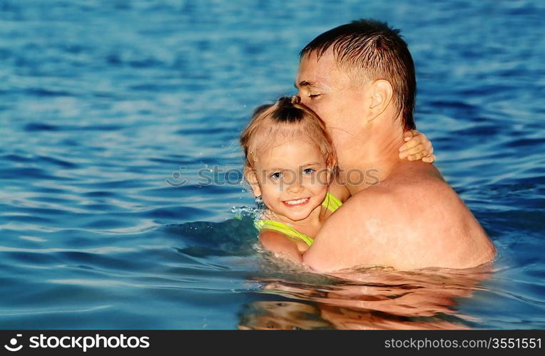 Color photo of father and daughter swimming in the sea