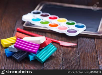 color plasticine on a table, plasticine on wooden background